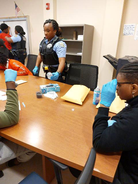 high school students in a workshop with the New Orleans Police Department learning about criminal justice